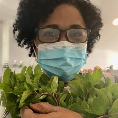 Woman holding freshly cut mint. 